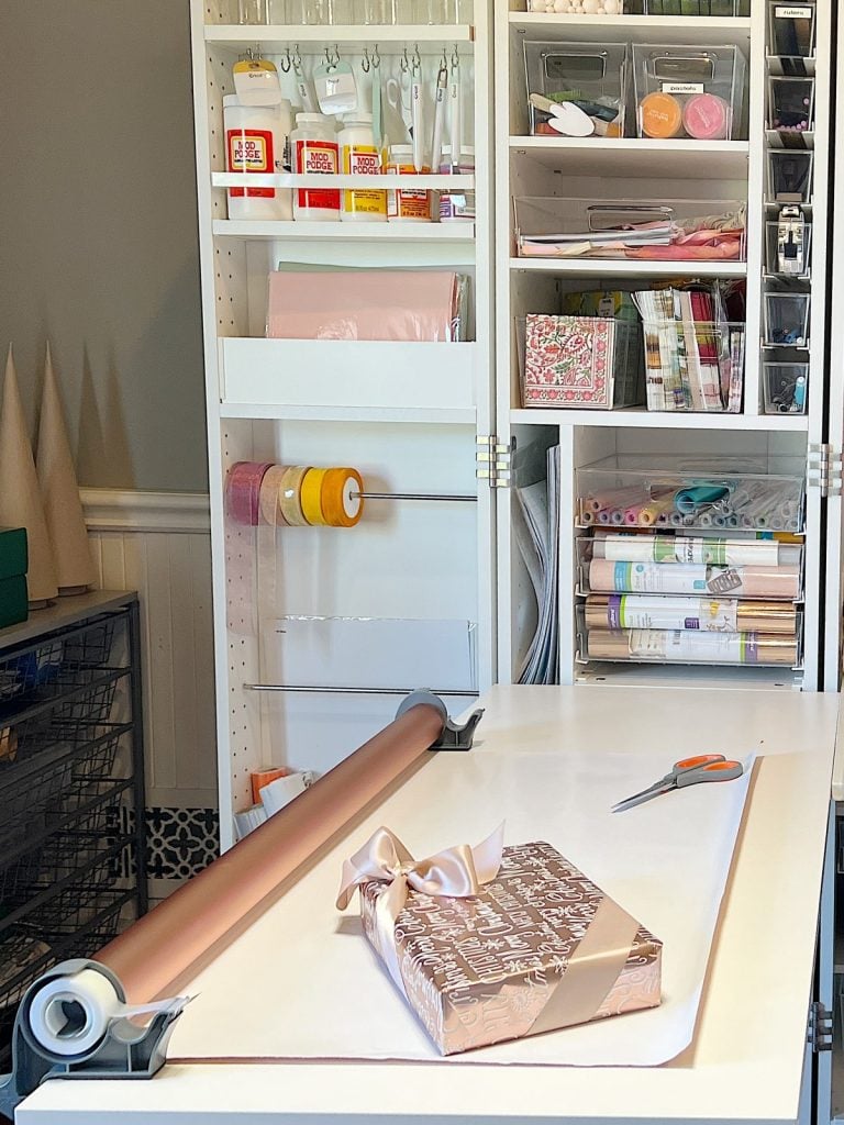 My craft room with a Dream Box filled with craft supplies and a wrapping paper table.