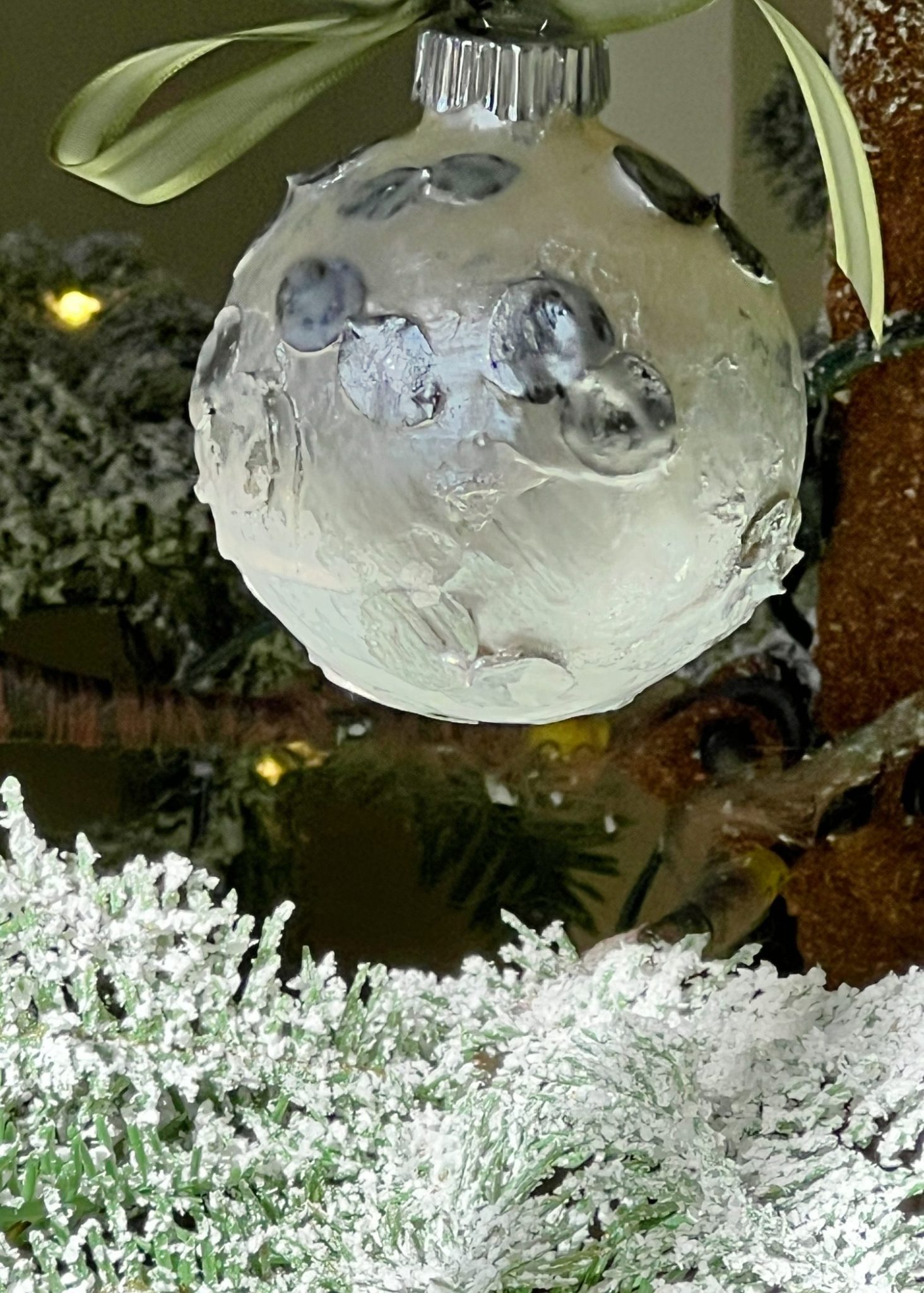 Handmade metallic glass Christmas ornaments made with metallic paint and small pine needles and leaves.