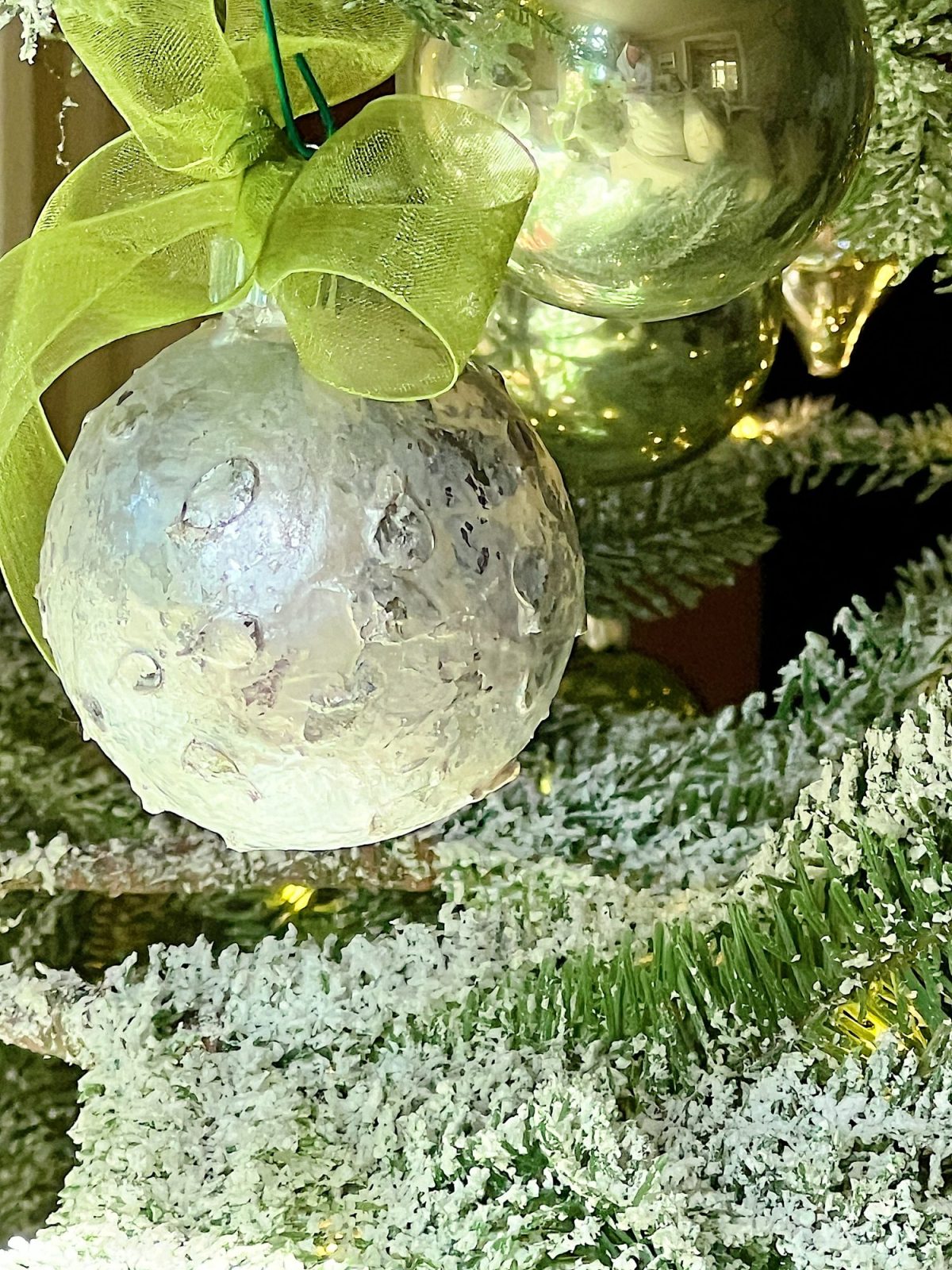 Handmade metallic glass Christmas ornaments made with metallic paint and small pine needles and leaves.