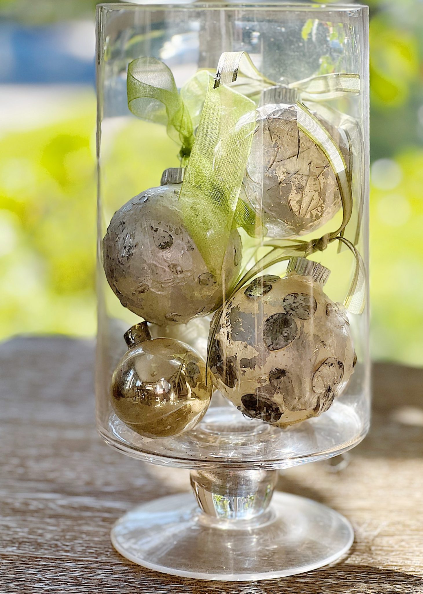 Handmade metallic glass Christmas ornaments made with metallic paint and small pine needles and leaves.