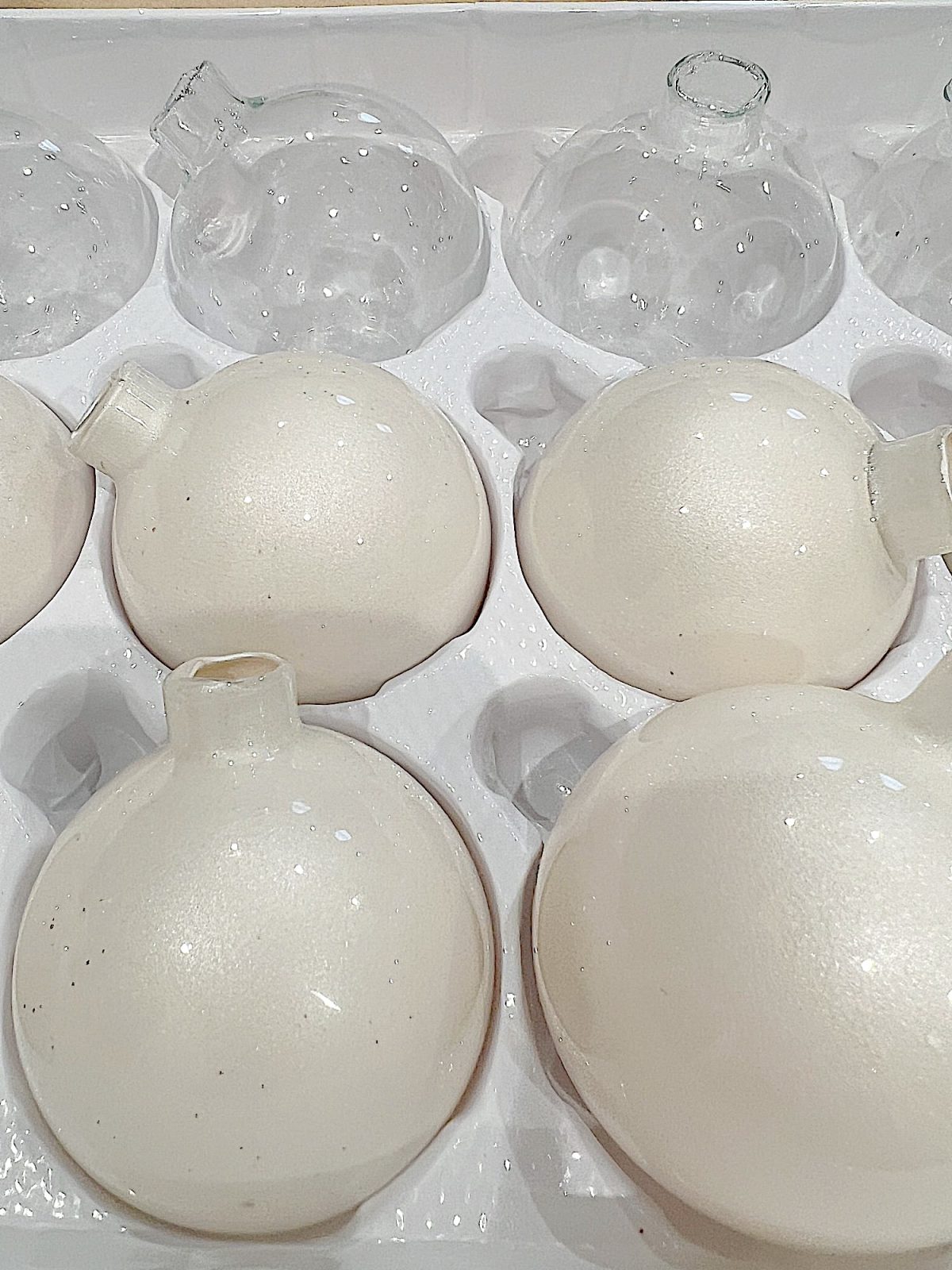 Handmade metallic glass Christmas ornaments made with metallic paint and small pine needles and leaves.