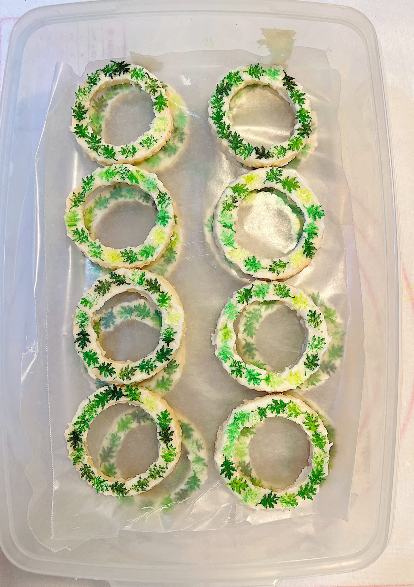 Homemade sugar cookies with buttercream frosting decorated with wafer paper wreaths.