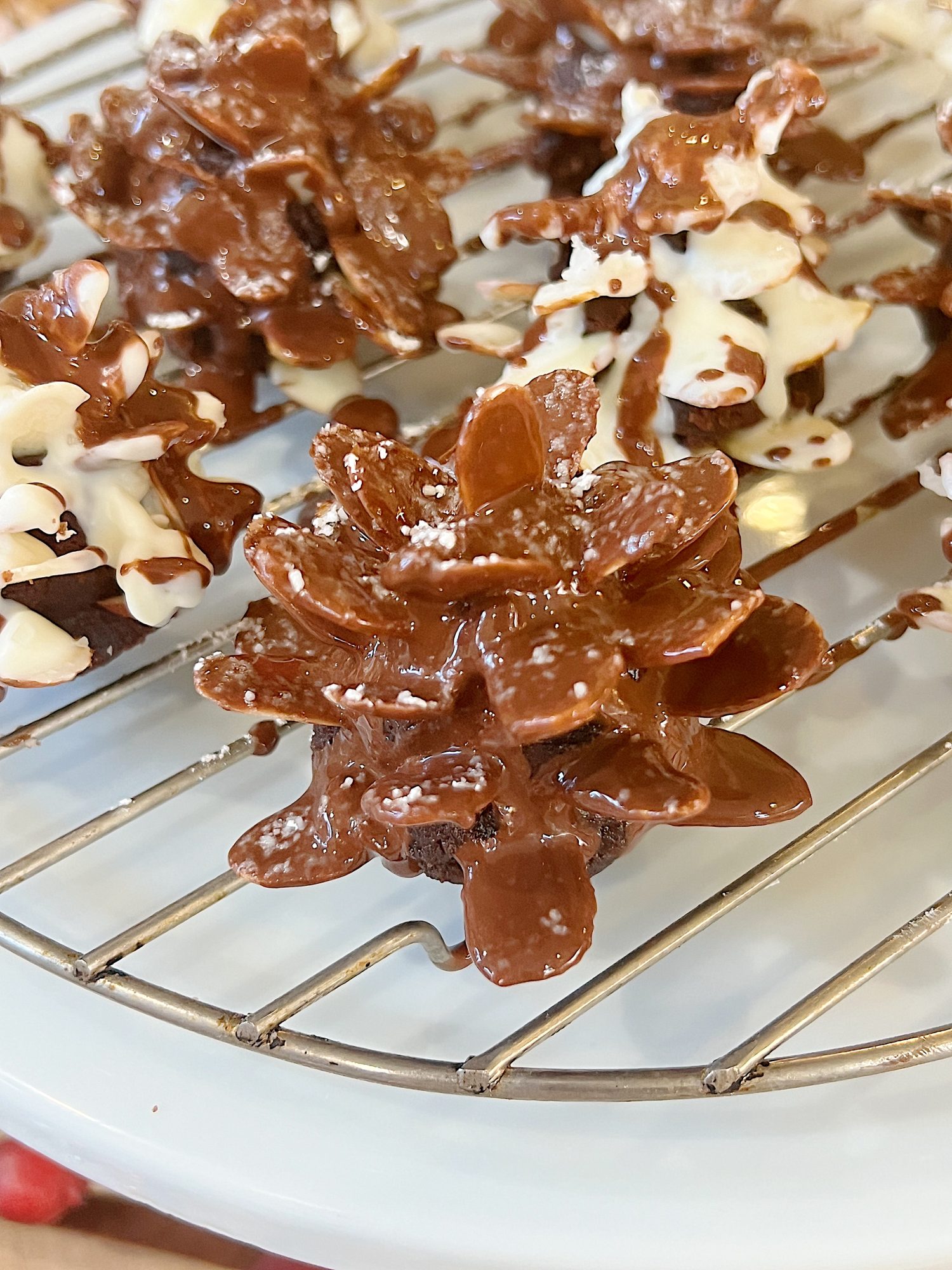 Homemade white chocolate covered brownie pinecones made from brownies, almonds, and melted chocolate.
