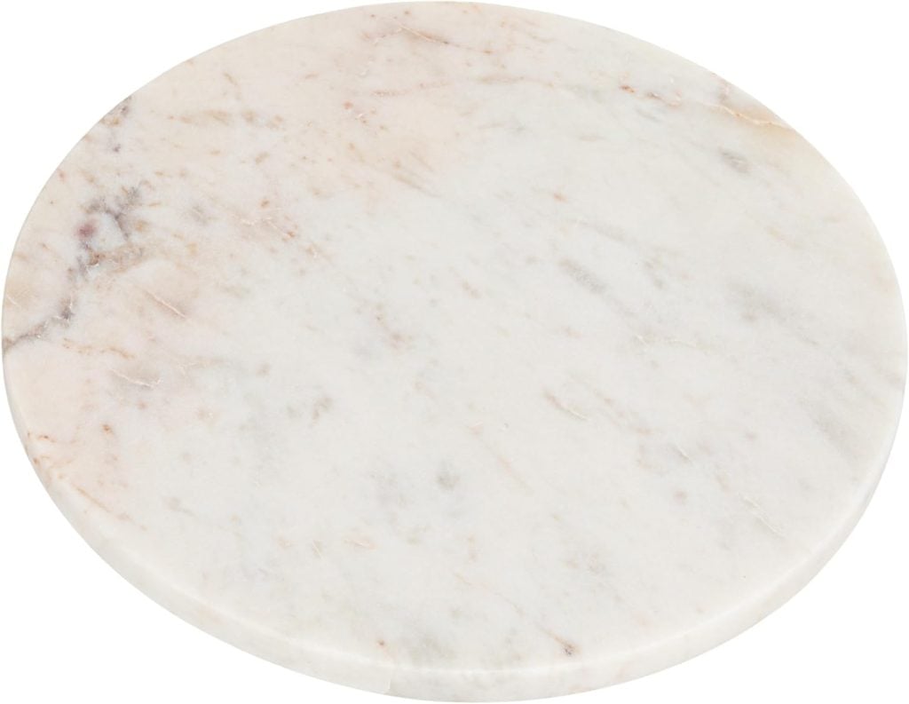 A round white marble slab with subtle gray and brown veining, perfect for serving slices of freshly baked pear bread at your next gathering.