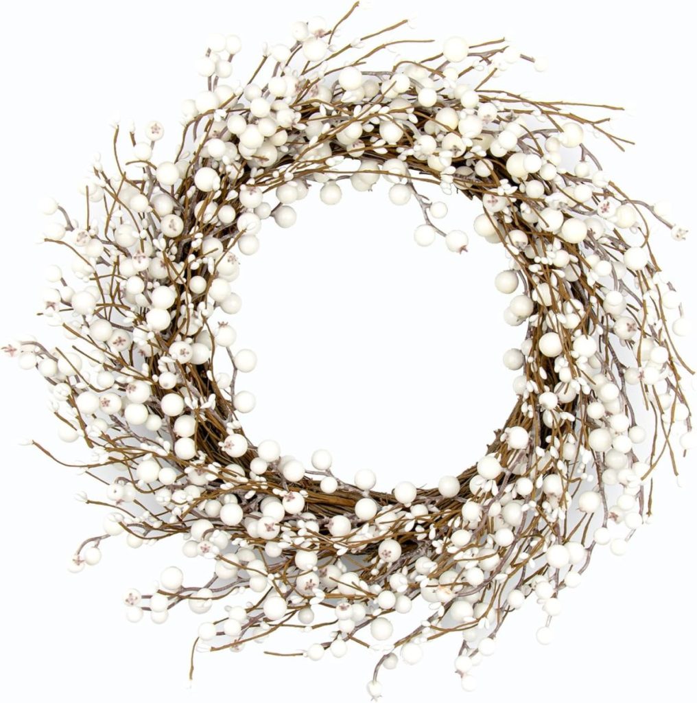 A Winter Wreath crafted from intertwined brown twigs and adorned with numerous small white berries, set against a crisp white background.