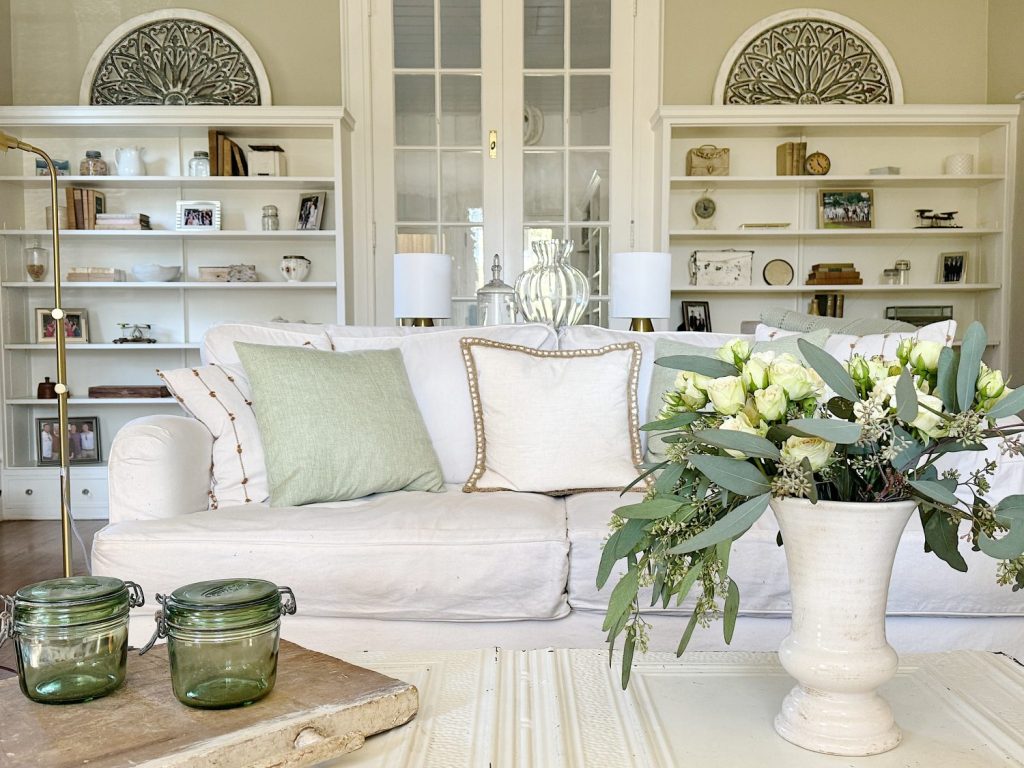A redecorated living room with sage and taupe and a mix of new and vintage items.
