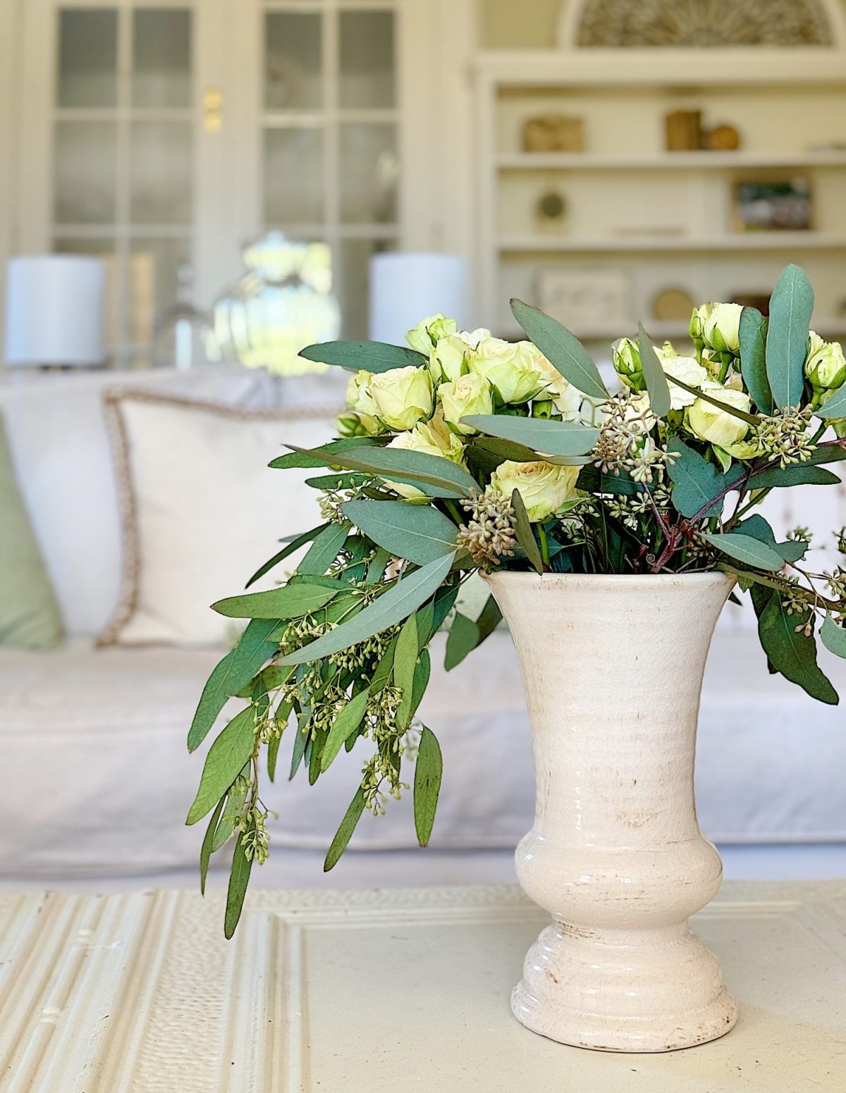 A redecorated living room with sage and taupe and a mix of new and vintage items.