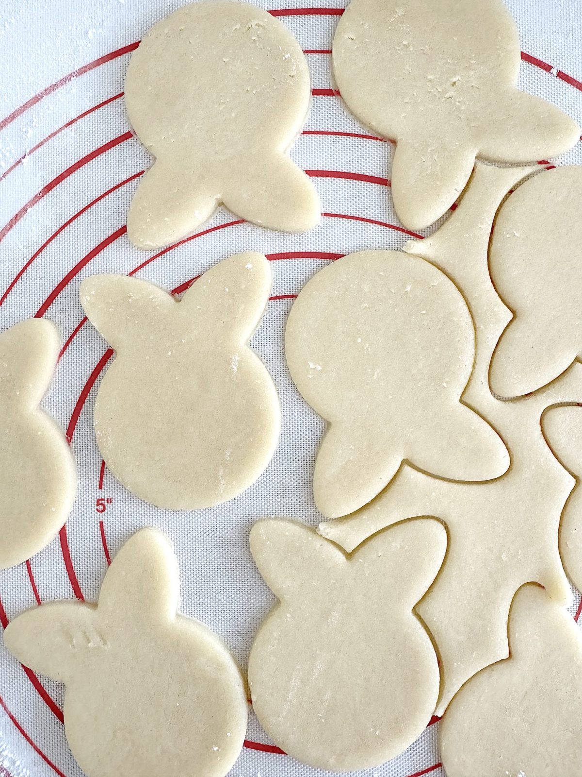 Flower shaped cookies decorated with bright colored buttercream frosting.