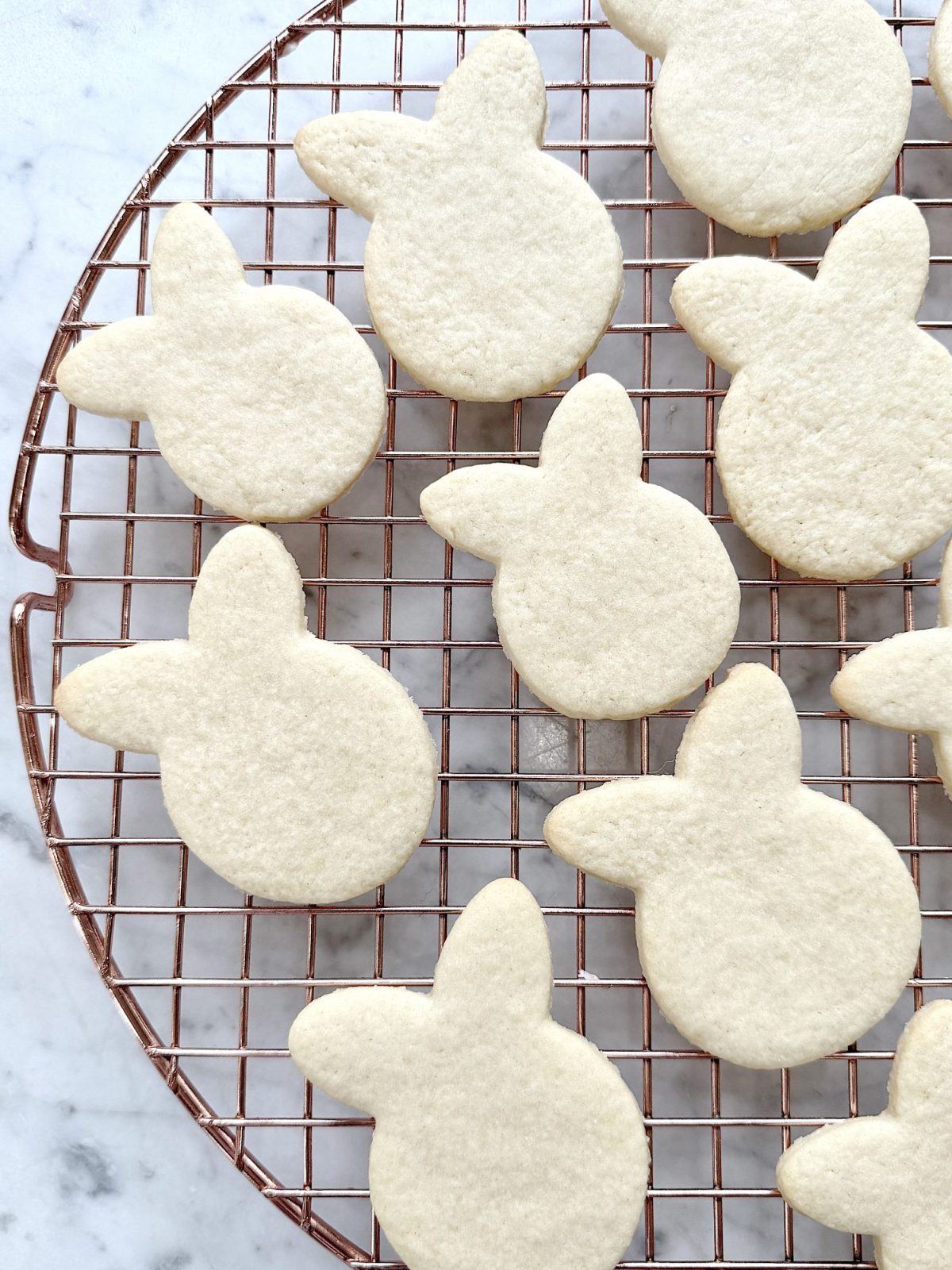 Flower shaped cookies decorated with bright colored buttercream frosting.