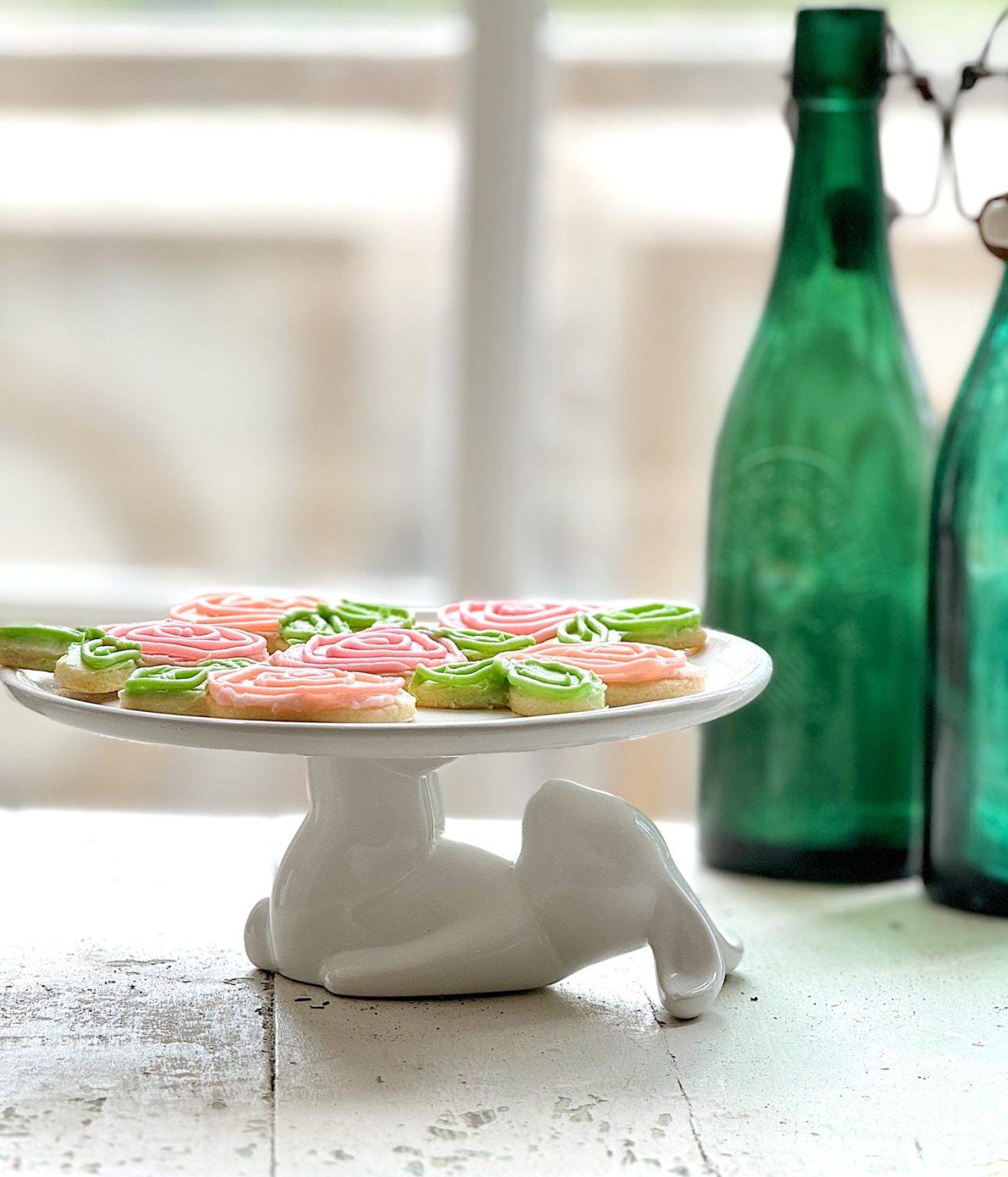 Flower shaped cookies decorated with bright colored buttercream frosting.