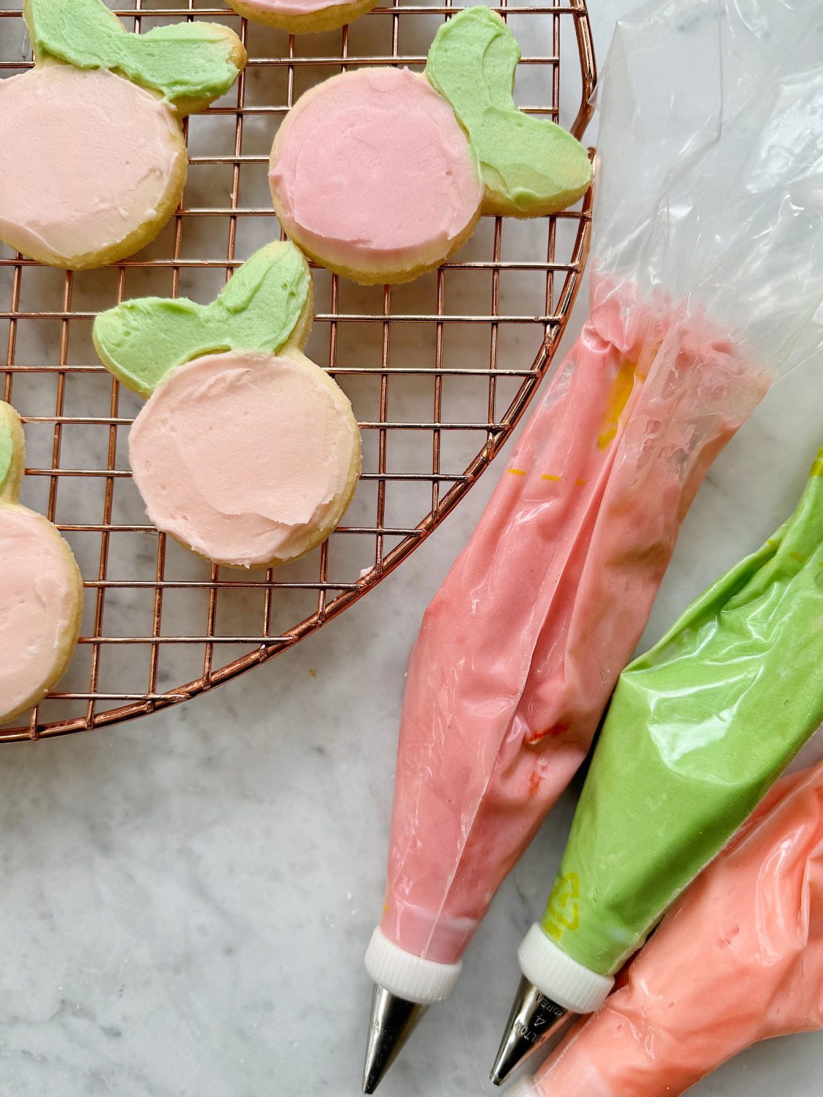 Flower shaped cookies decorated with bright colored buttercream frosting.