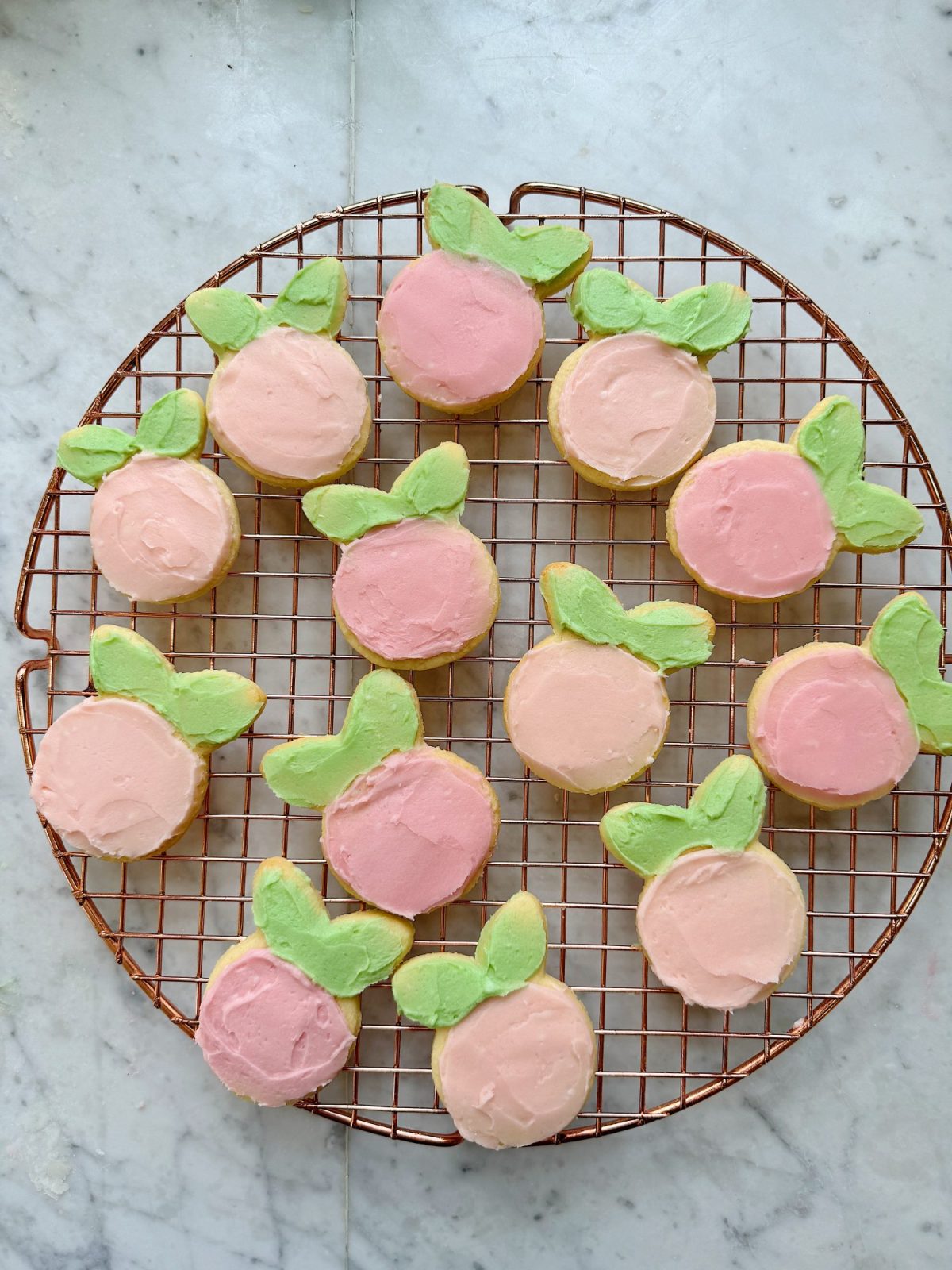 Flower shaped cookies decorated with bright colored buttercream frosting.