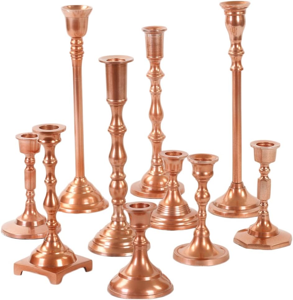 A collection of copper candle holders in various sizes and designs, perfect for an outdoor party.