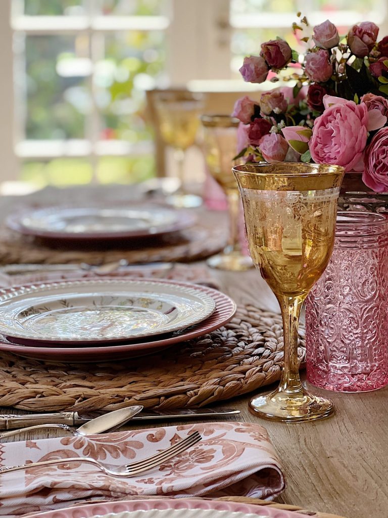 Elegant table setting with floral centerpiece and vintage glassware.