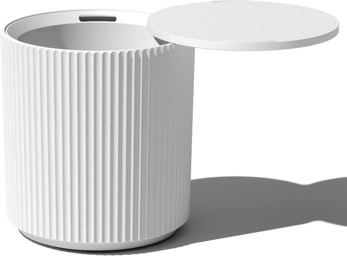 A white cylindrical trash can with a ribbed texture and an open lid is perfectly suited for your outdoor cooking station, casting a subtle shadow on the ground.
