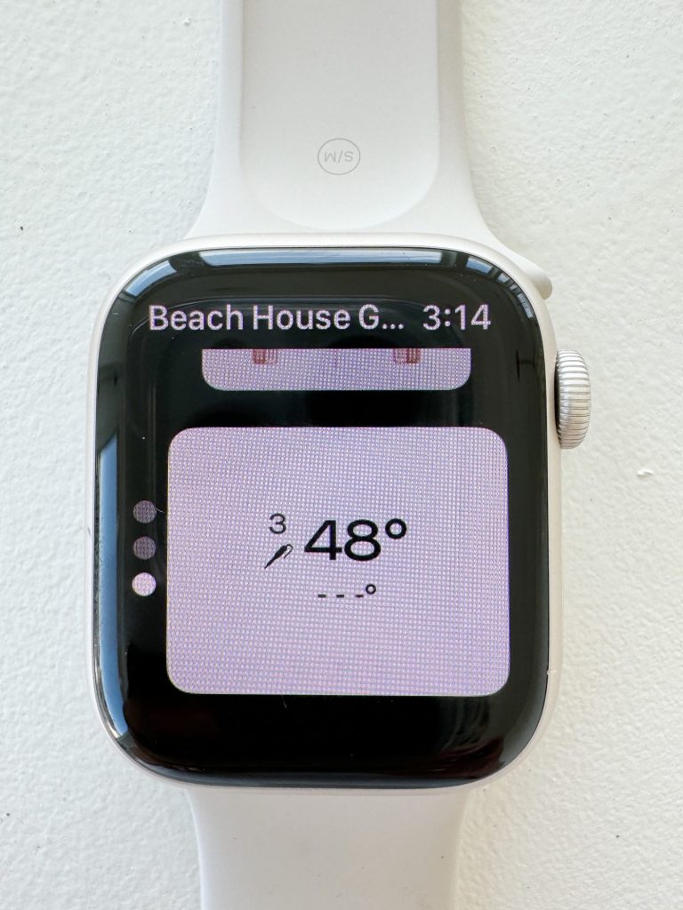 Smartwatch displaying a weather app with a temperature of 48 degrees on a white band against a white background.