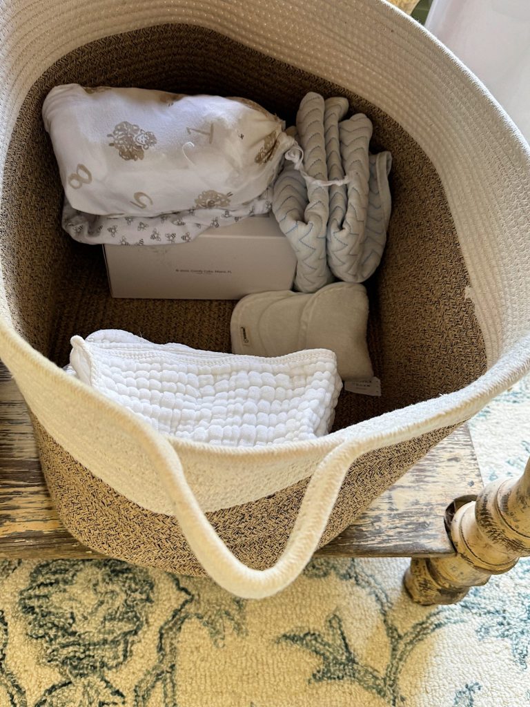 A cozy nursery with rustic wooden table with baskets underneath by a window.
