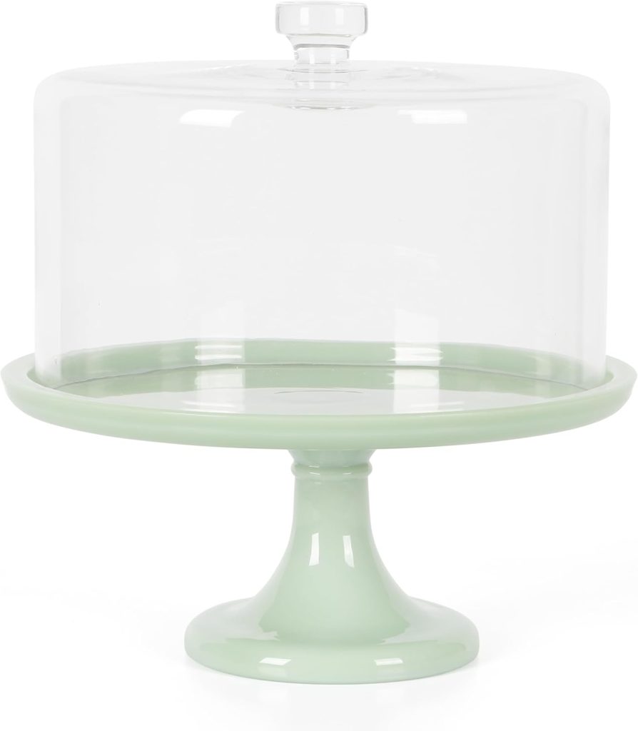 A pale green cake stand with a tall, clear glass dome cover, perfect for displaying cakes decorated with delicate edible paper accents.