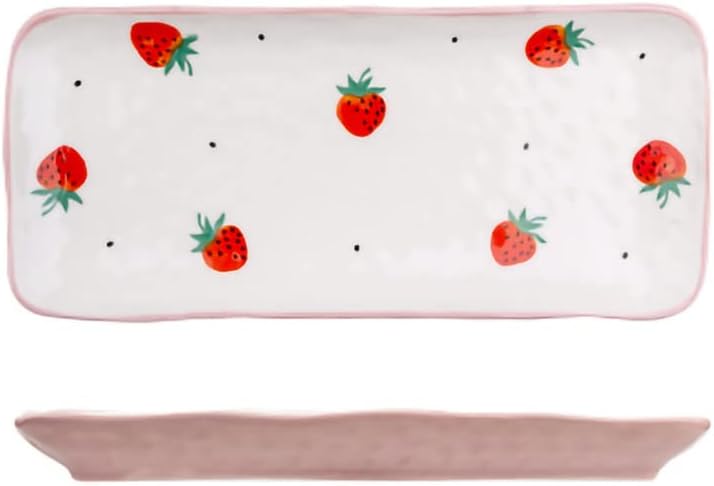 Rectangular white ceramic plate with a pink rim, decorated with scattered red strawberries and small black dots reminiscent of mixed berry accents. Side view shows the plate's shallow depth.