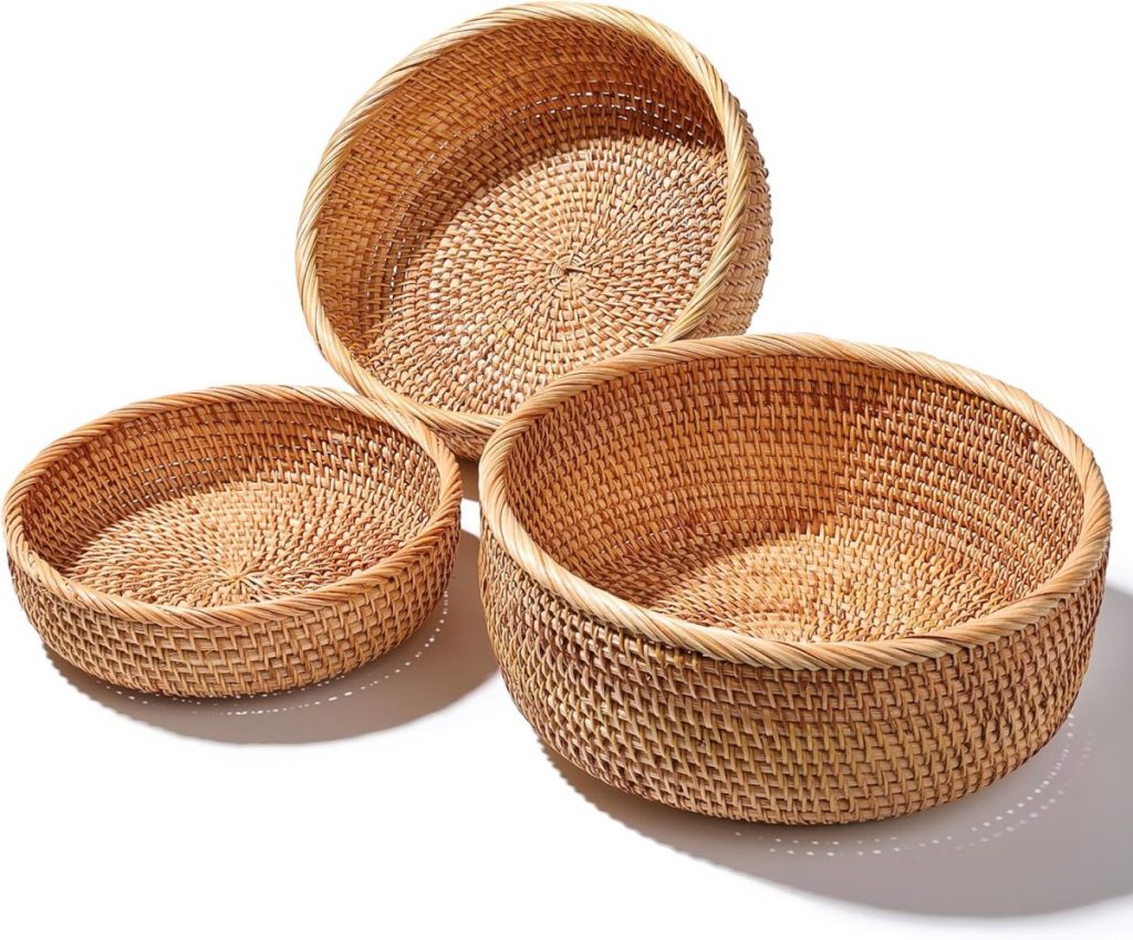 Three round, woven wicker baskets of varying sizes are arranged together on a white background, perfect for use as a decorative bread basket set.
