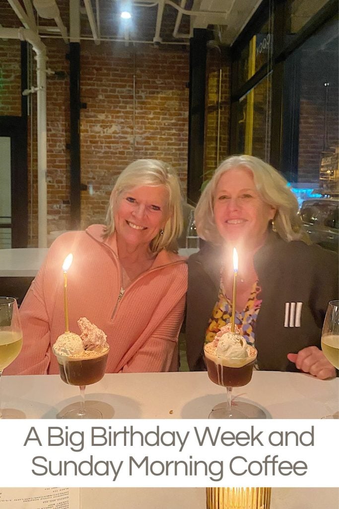 Two women smiling at a table with glasses of wine and desserts with lit candles, in a cozy brick-walled cafe. Text below reads "A Big Birthday Week and Sunday Morning Coffee.