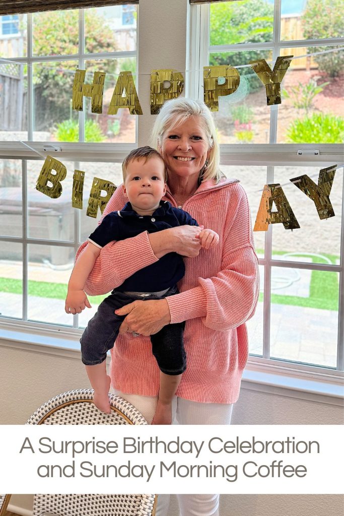 An older woman holds a baby while standing in front of a "Happy Birthday" banner during a surprise birthday celebration. The caption below reads "A Surprise Birthday Celebration and Sunday Morning Coffee.