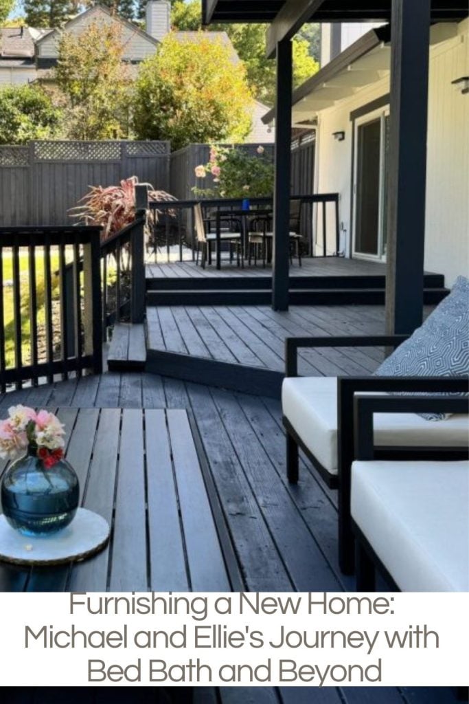 Outdoor deck with black wood, white cushioned seating, a small table with flowers, and a dining area in the background. Text overlay: "Furnishing a New Home: Michael and Ellie's Journey with Bed Bath and Beyond.