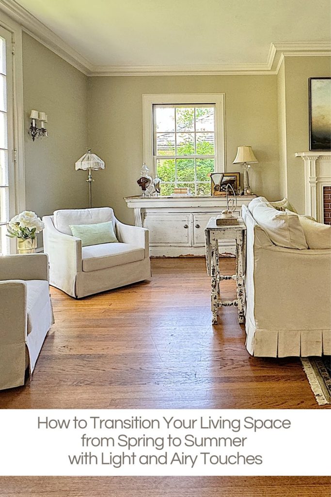 A cozy living room with white armchairs, a sofa, a small table, and natural light streaming in through large windows. A caption below the image provides a decorating tip for seasonal transitions.