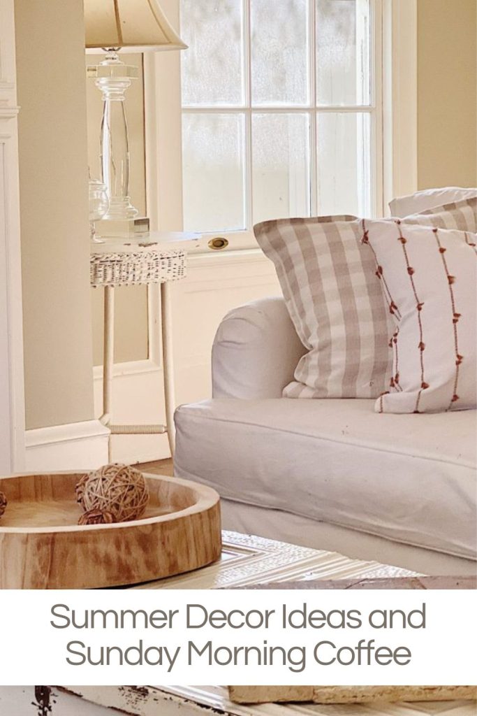 A cozy living room with a white sofa, patterned pillows, a small side table with a table lamp, and a window. Text reads "Summer Decor Ideas and Sunday Morning Coffee.