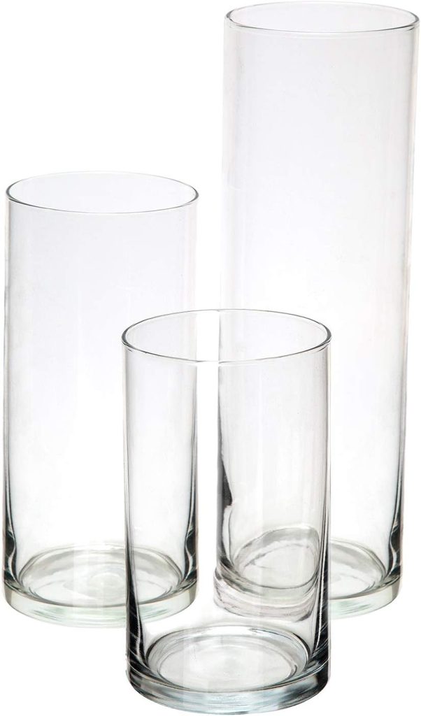 Three clear, empty glass cylinders of varying heights and widths are placed next to each other on a white background, ready to be filled with pressed flowers.