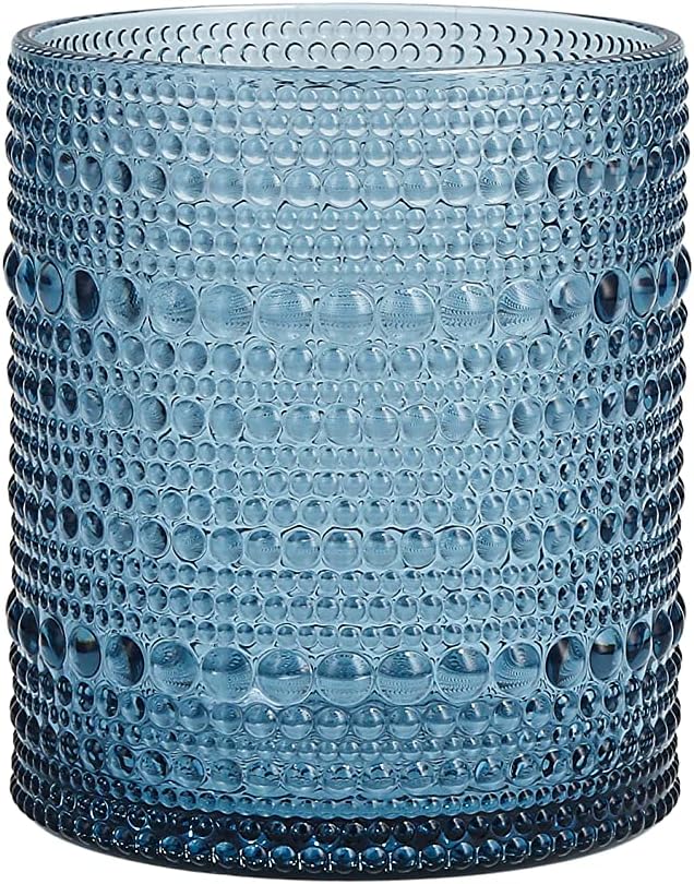 A cylindrical blue glass tumbler with a textured, hobnail pattern covering its surface—perfect for sipping cool drinks on a summer beach.