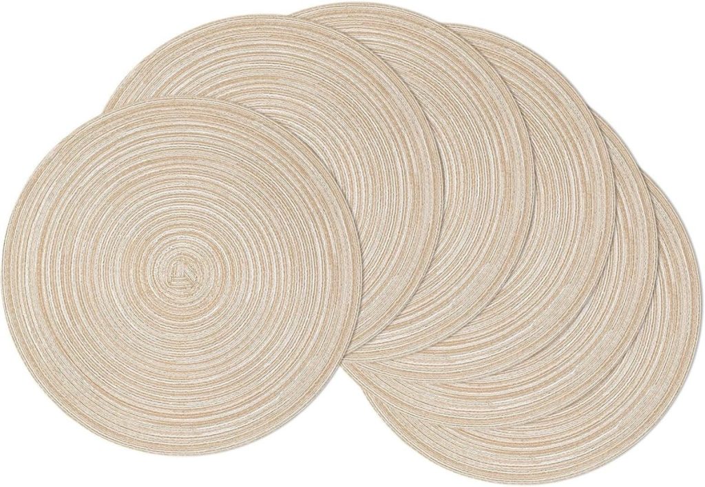 Five round, beige woven placemats are overlapping on a white background, adding a touch of summer beach charm to your table setting.