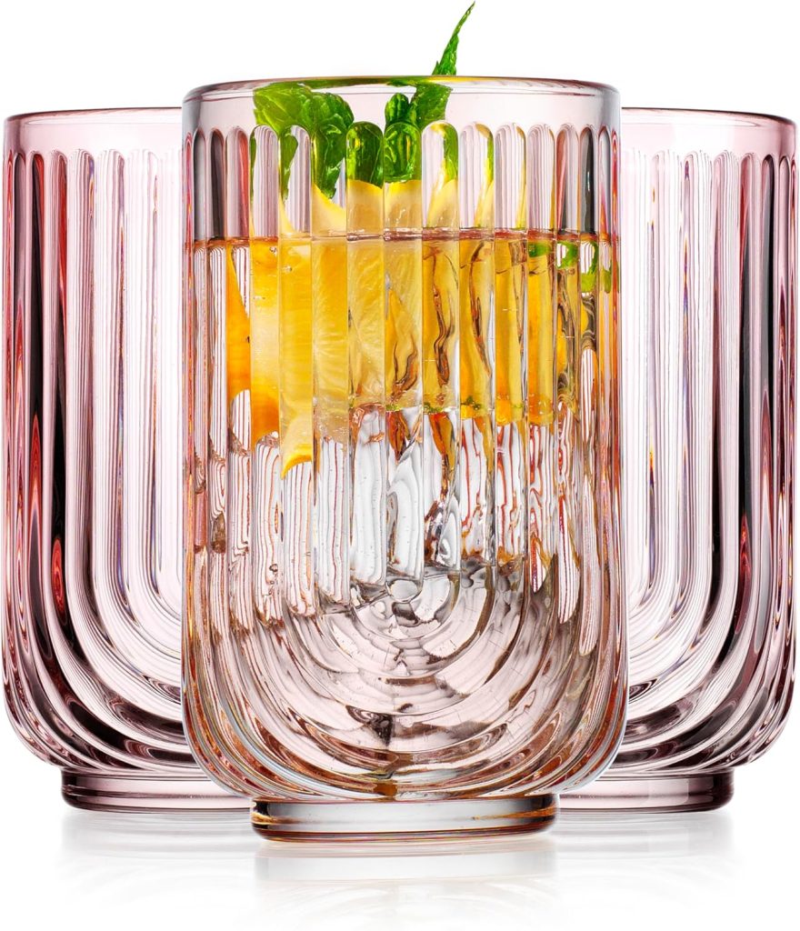 Three ribbed pink drinking glasses, with one in front containing the best iced tea, ice, lemon slices, and mint leaves.