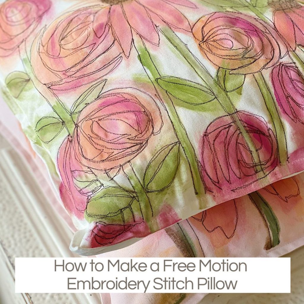 A Creative Crafts pillow decorated with free motion embroidery stitch in a floral design, featuring pink, peach, and green watercolor-like accents. Text reads: "How to Make a Free Motion Embroidery Stitch Pillow.