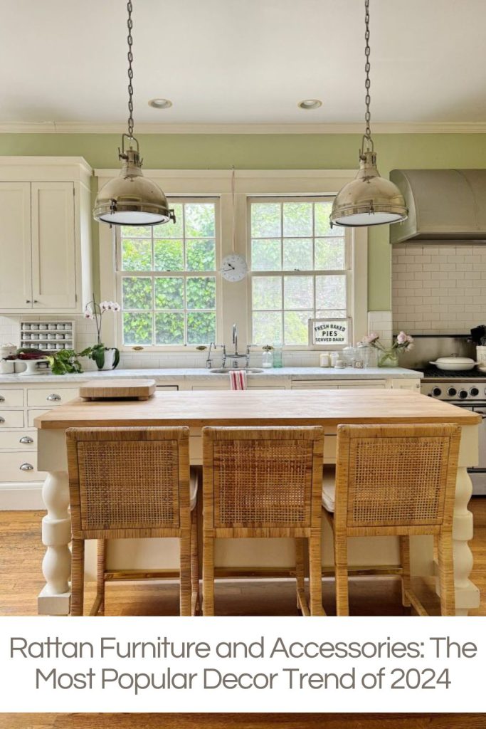 A kitchen with a large island, three rattan chairs, a rattan shelf, white cabinets, a stovetop, and hanging lights, highlighting rattan furniture as a trend for 2024.