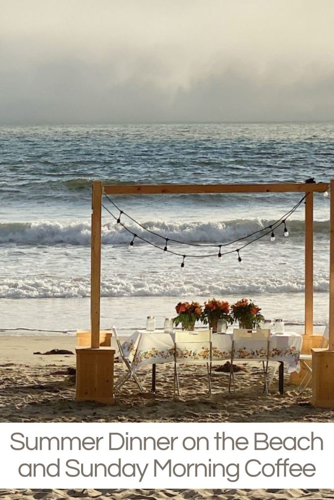 A wooden canopy with string lights shelters a table with flowers set for a meal on a beach. The tide is low, and the sky is overcast. Text reads "Summer Dinner on the Beach and Sunday Morning Coffee.