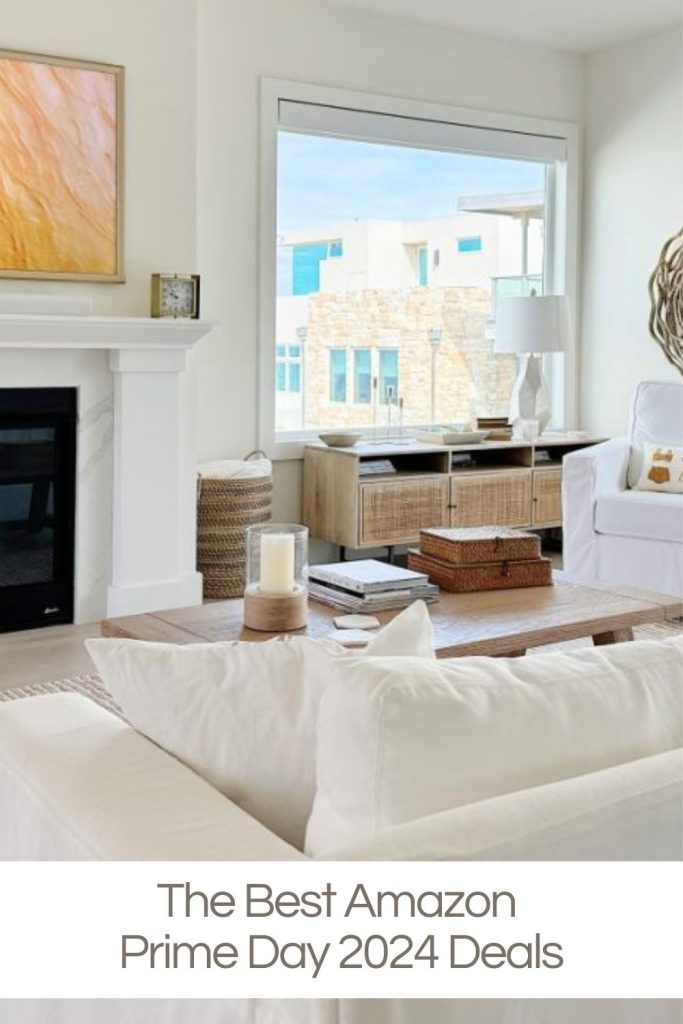 Living room with white furniture, fireplace, and large window. Text overlay: "The Best Amazon Prime Day 2024 Deals".