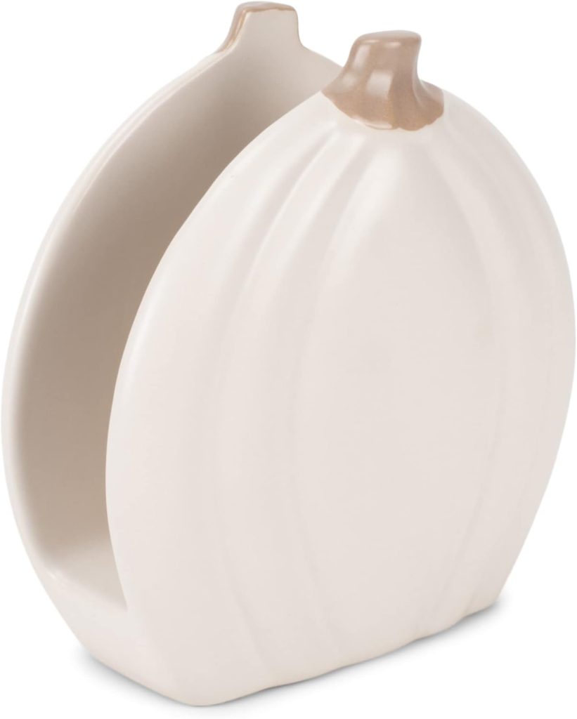 A white ceramic napkin holder shaped like a pumpkin with a light brown stem, perfect for adding a touch of fall home decor to your table.