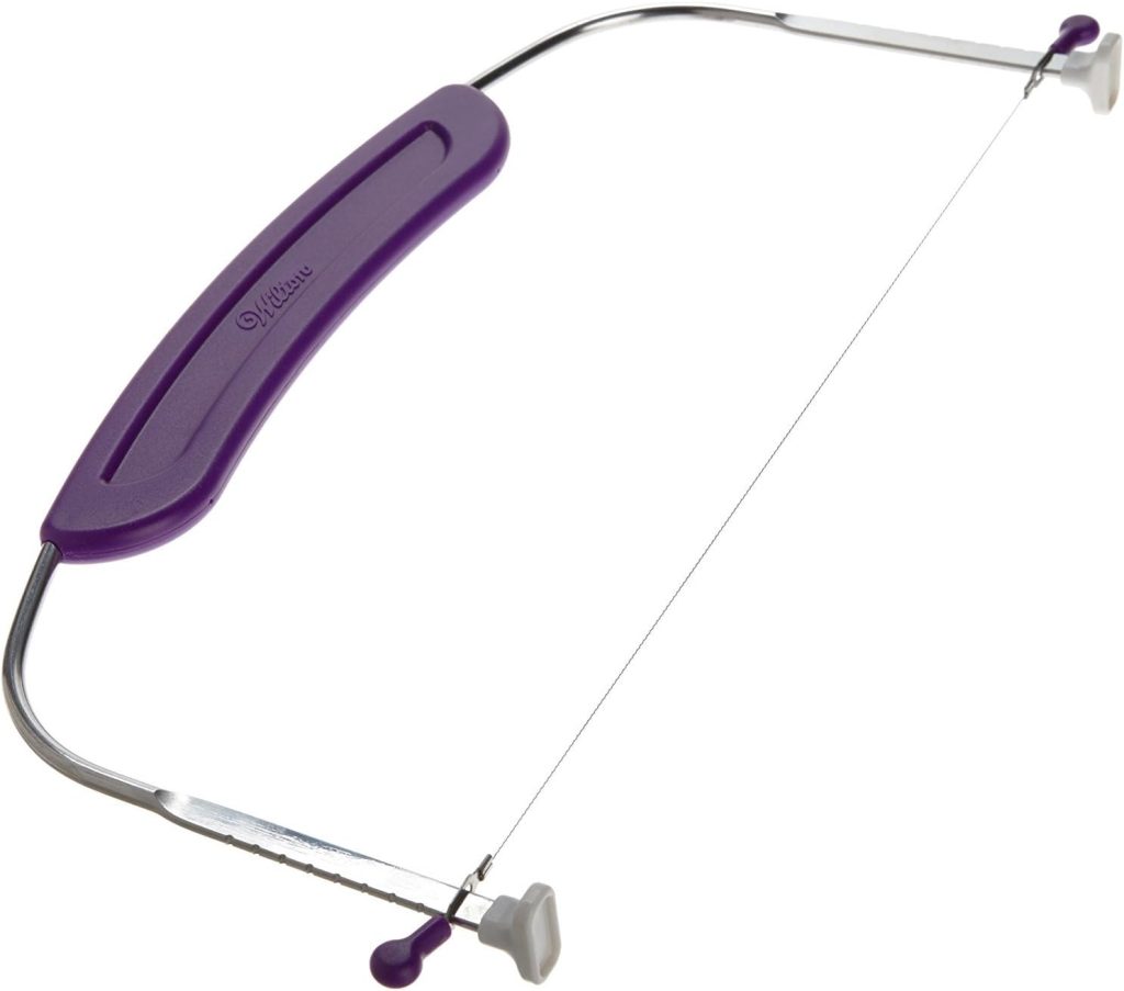A metal cake leveler with a purple plastic handle and an adjustable wire—perfect for slicing flower cakes evenly every time.
