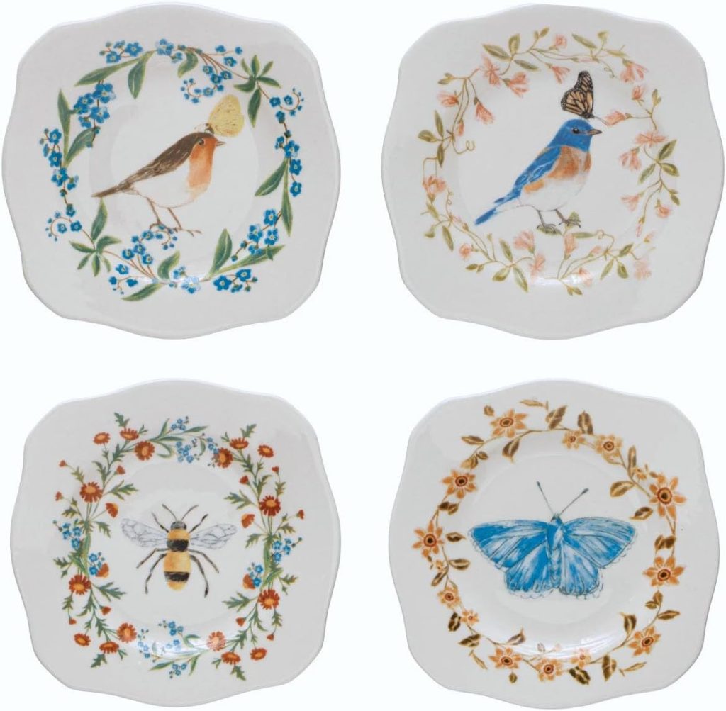 Four decorative plates with scalloped edges, each featuring a different design—a robin, a blue bird, a bee, and a blue butterfly surrounded by floral patterns—perfect for serving your favorite marshmallow dessert.