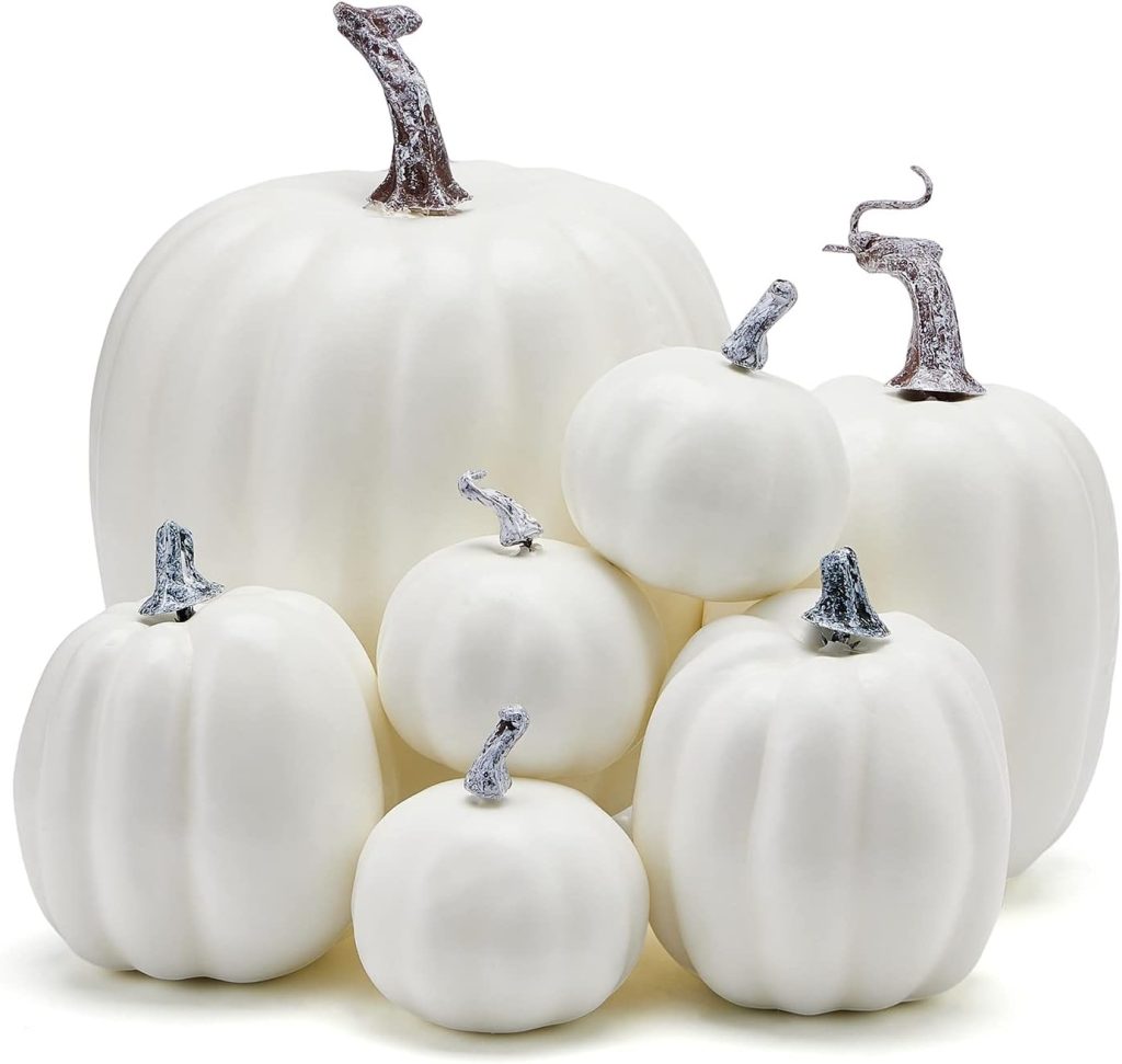 A group of seven white pumpkins of varying sizes with metallic silver stems, perfect for pumpkin crafts, arranged together against a plain background.