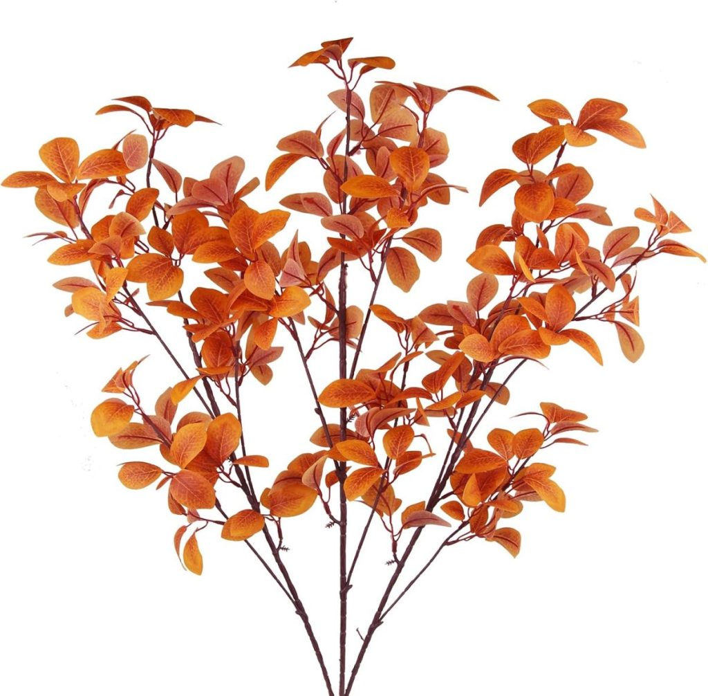 Five stems of artificial branches with orange autumn leaves make perfect fall home decor, set against a white background.
