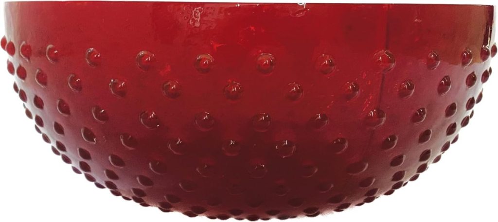 A red, round bowl with a textured surface featuring raised bumps evenly distributed across its exterior—perfect as fall room decor to add a warm, seasonal touch.