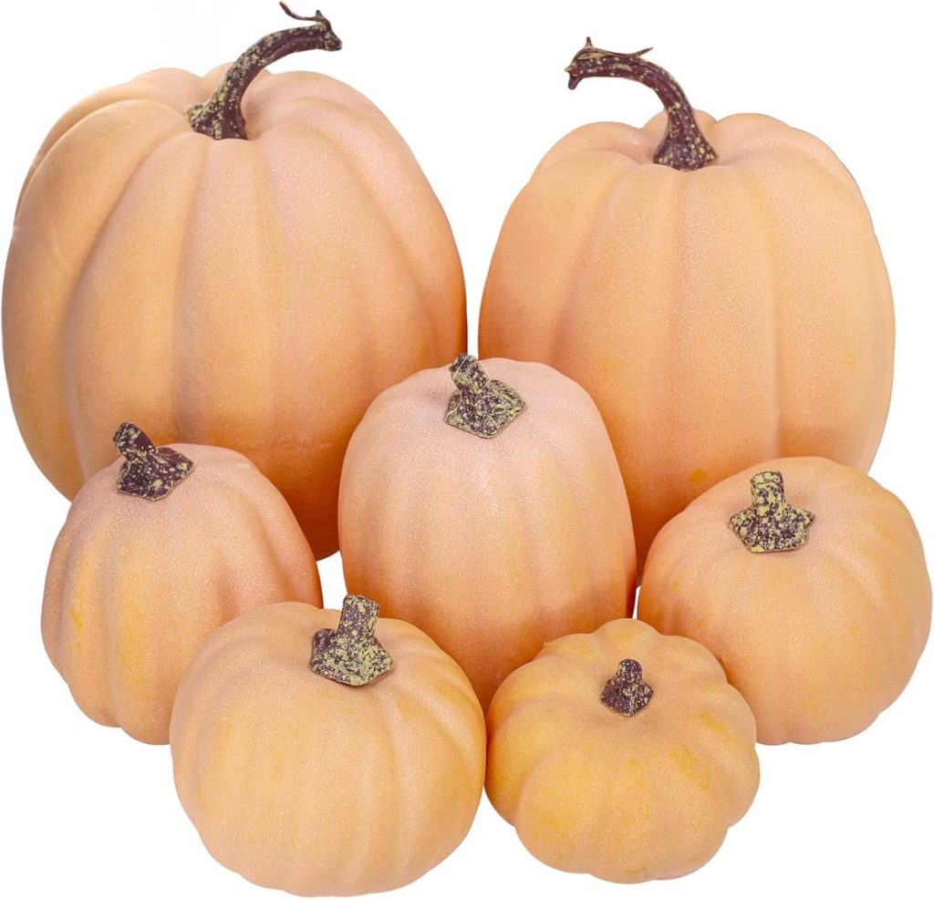 Seven light orange pumpkins of various sizes are grouped together on a white background, perfect for inspiring pumpkin crafts.