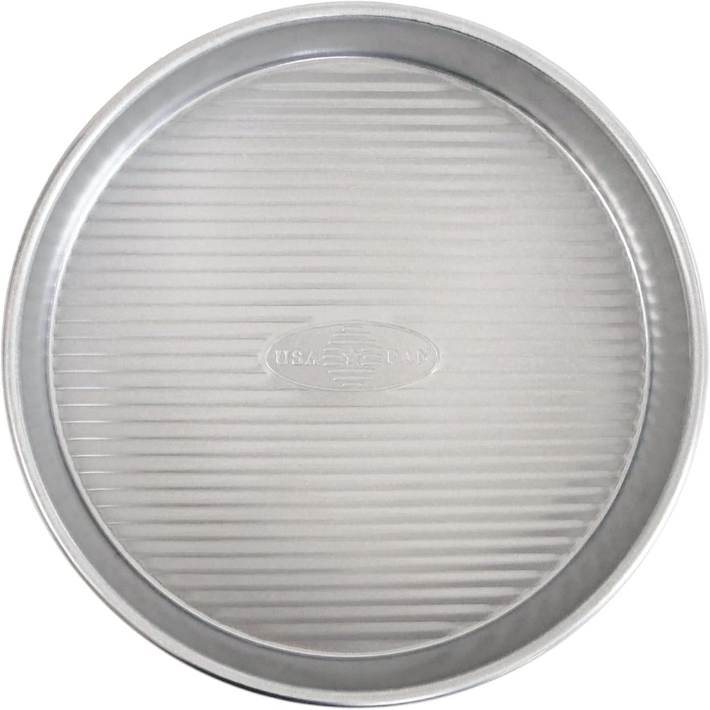 Round, silver metal baking pan with a ribbed texture on the bottom, perfect for baking a beautiful flower cake. Features the "USA PAN" logo embossed in the center.