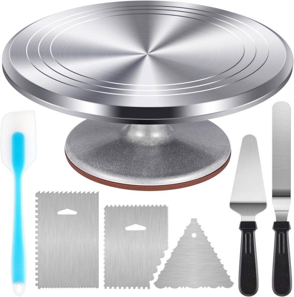 A stainless steel cake turntable with two offset spatulas, a silicone spatula, and three metal icing scrapers—perfect for creating a stunning flower cake—arranged neatly on a white background.