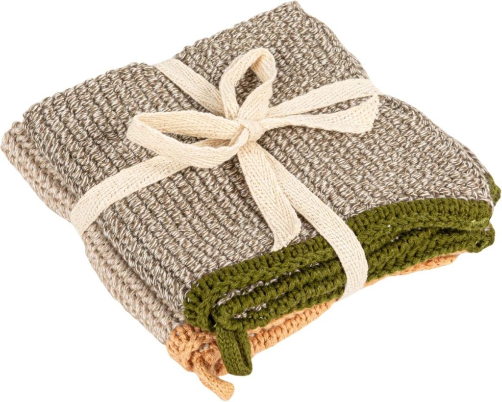 A set of folded knitted dishcloths in neutral tones, tied together with a cream-colored fabric ribbon—perfect for adding a cozy touch to your fall home decor.