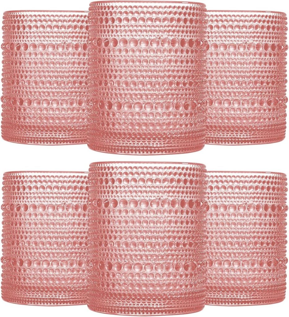 Six pink textured cranberry glass tumblers are arranged in two rows, each with a pattern of raised dots covering the surface.