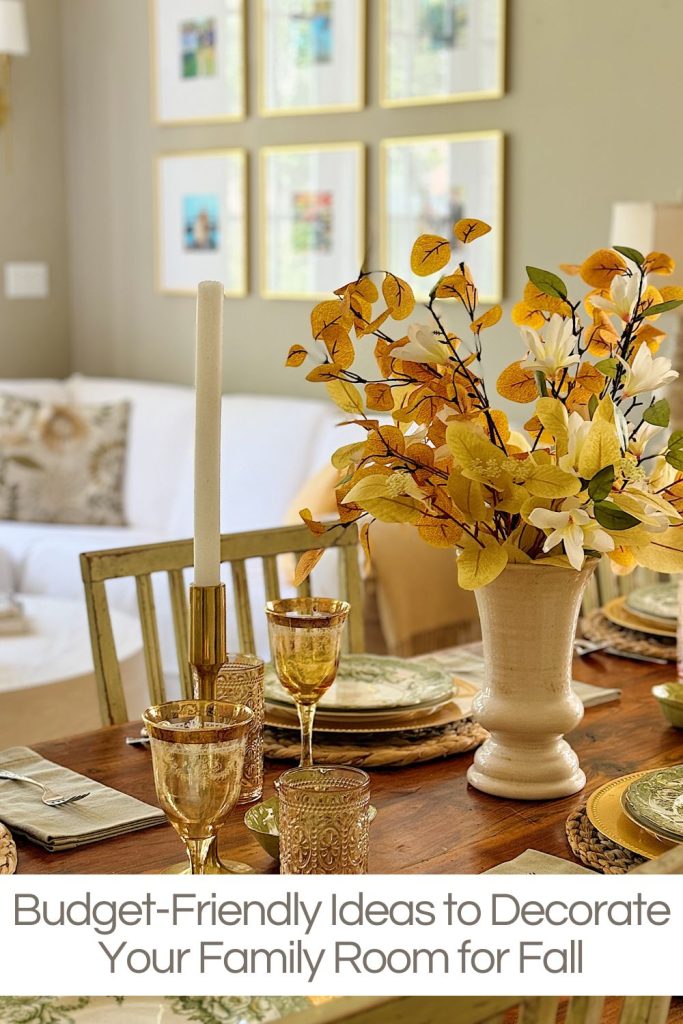 A dining table is decorated with a fall-themed centerpiece and place settings. In the background, a sofa and framed pictures are visible. Text at the bottom reads, "Budget-Friendly Ideas to Decorate Your Family Room for Fall.