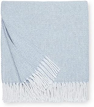 A folded, light blue herringbone throw blanket with fringed edges.